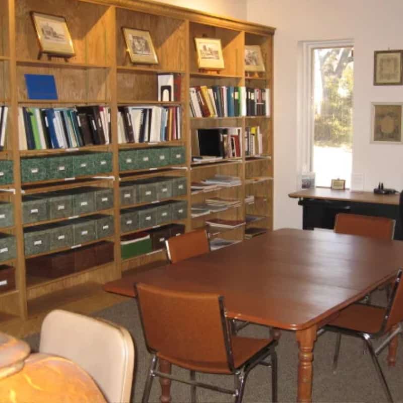 A table with four chairs alongside library shelves