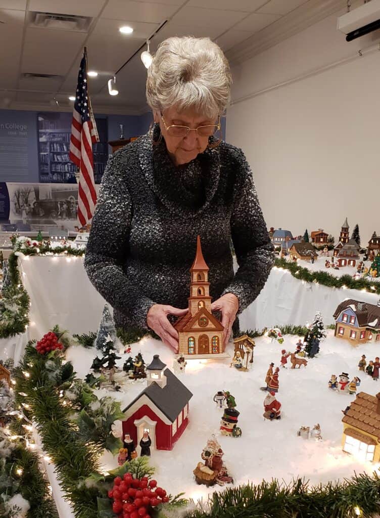 Marilyn Owenby places the church amid her display in 2022.