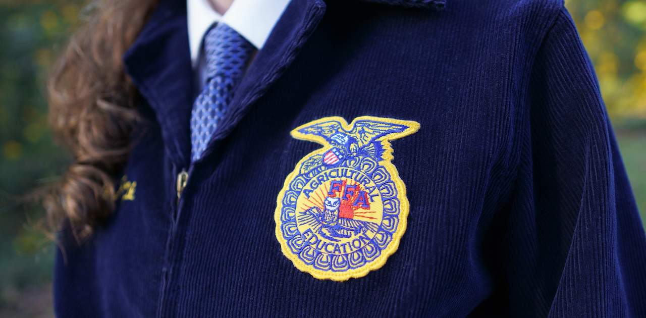 Girl wearing a blue FFA Jacket.