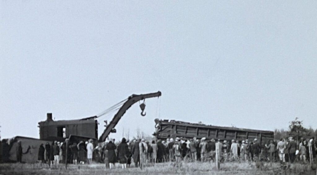 Crew lifts remains of damaged train car.